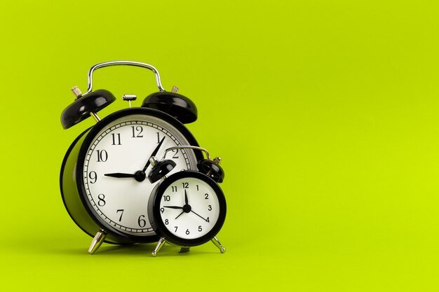 despertador-preto-vintage-em-um-fundo-verde-brilhante_127657-1314