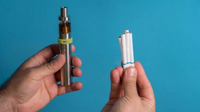 Men holding electronic cigarette on colored background background