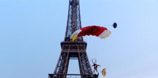 Detienen a hombre por escalar la torre Eiffel y saltar en paracaídas
